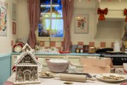Mrs Claus' messy Kitchen, with a gingerbread house on the table. 
