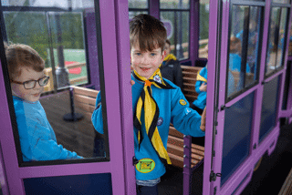 Young boy smiling out of the train door