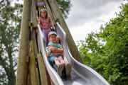 3 kids sliding down teepee slide