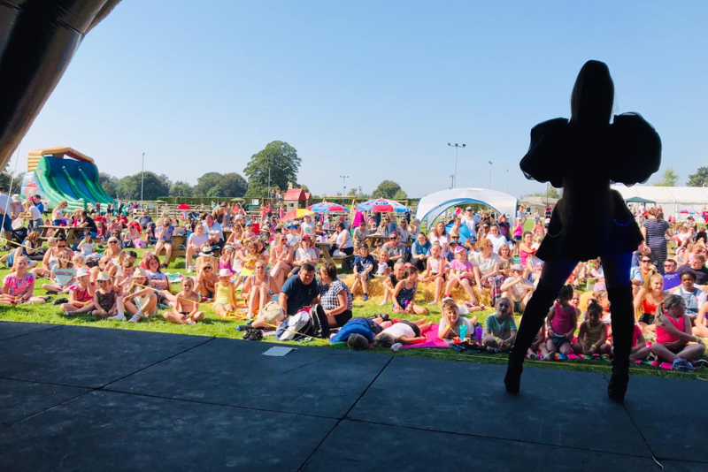 live singer performing on festival stage in front of a crowd