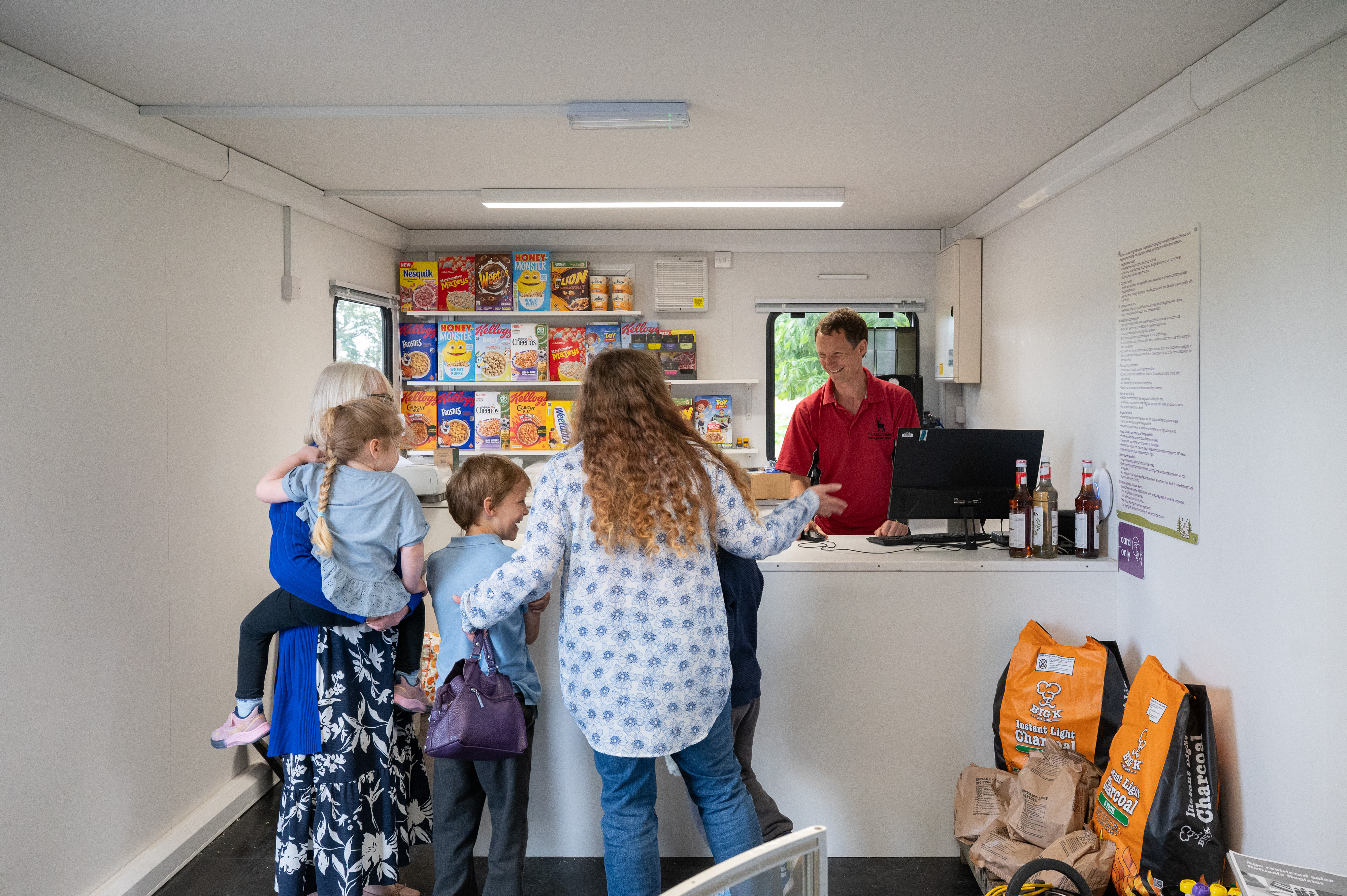 Stockeld Employee Serving Group Of Customers At Camp Shop