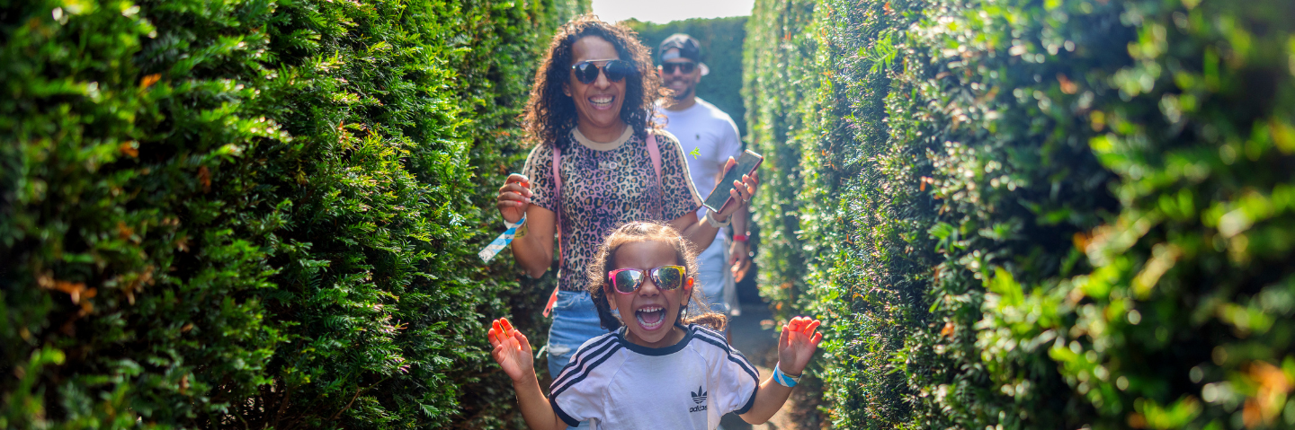 A family walking through the Magical Maze at Stockeld Park.