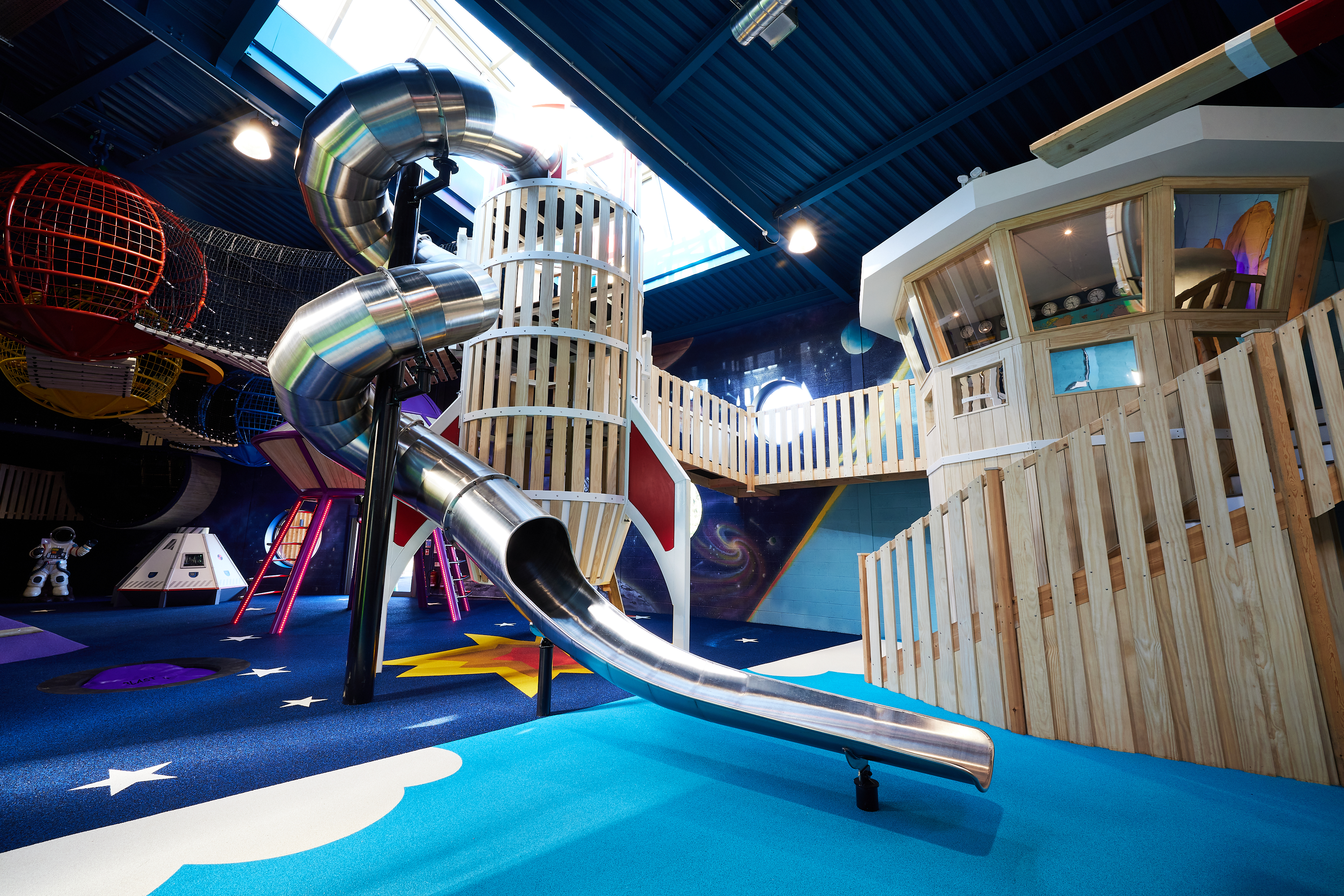 spiral slide in space and air section of indoor playground the playhive