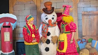 two elves and a snowman on stage