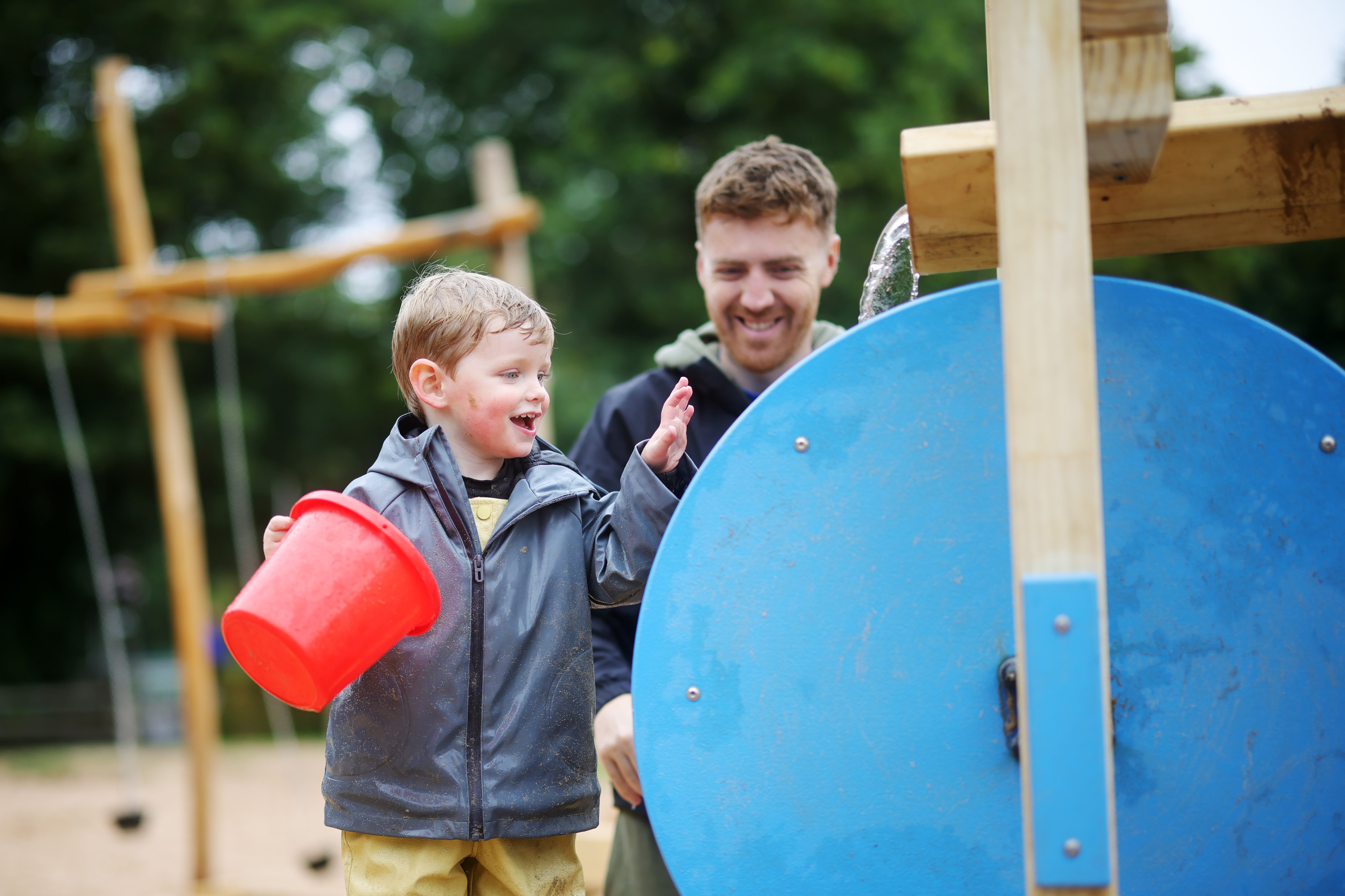JG Summer 2026 Young Guest Laughing While Holding Red Bucket