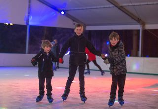 3 boys holding hands ice skating