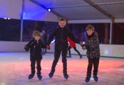 3 boys holding hands ice skating