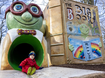 boy wearing wellies coming down slide
