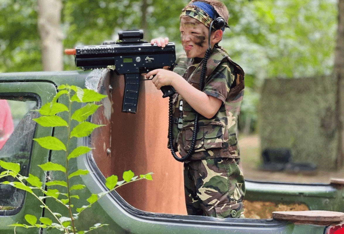 Kid shooting a laser gun with full camo