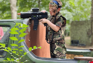 Kid shooting a laser gun with full camo