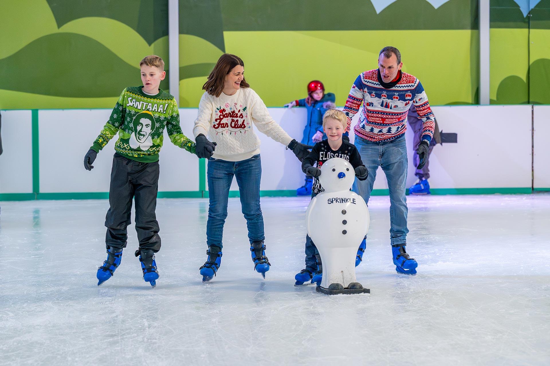 family wearing christmas jumpers ice skating together