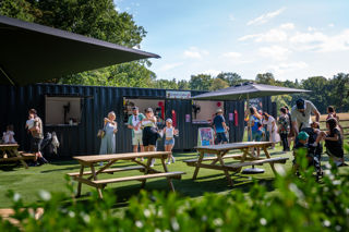 catering cabin and picnic area with benches and umbrellas set in a forest