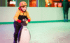 A boy learning to ice skate with a penguin aid