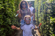 Family smiling and running through the maze