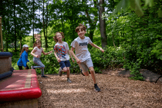 4 kids running round the big book of books