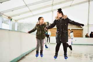 mum and dad holding hands while skating