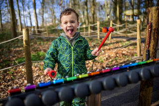 boy playing musical instrument in forest