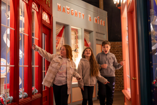 Three children explore the North Pole village inside the Grotto dome at Stockeld Park.