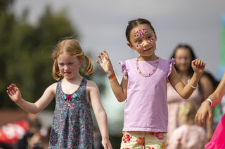 two girls dancing at a festival with face paint