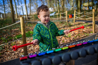Image of a small boy in a green jacket enjoying outdoor play