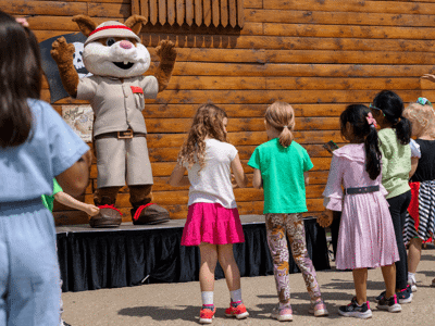 Scout stood on stage waving at some children