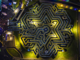 overhead view of a christmas snowflake maze with lights