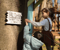 Two children pressing figgy pudding's doorbell