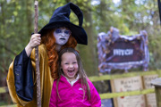 witch in gold robes and ginger hair scowls with girl laughing