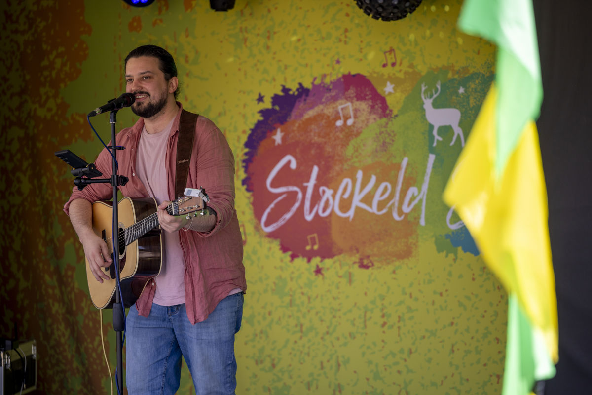 man singing on stage playing guitar
