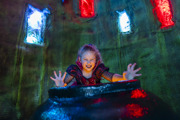 girl in halloween costume growls at camera with a witches cauldron
