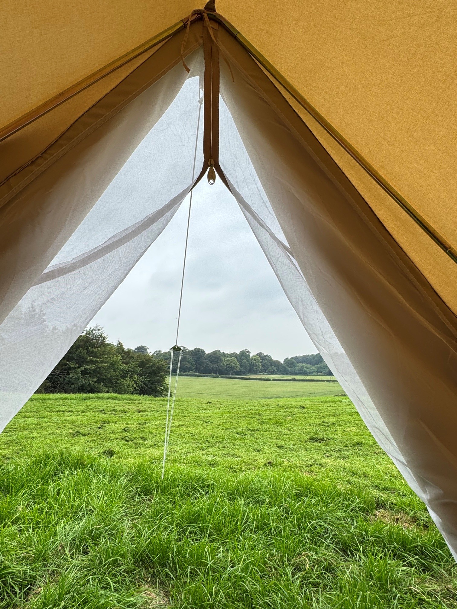The View From Inside A Tent Looking Out Over Fields And Trees