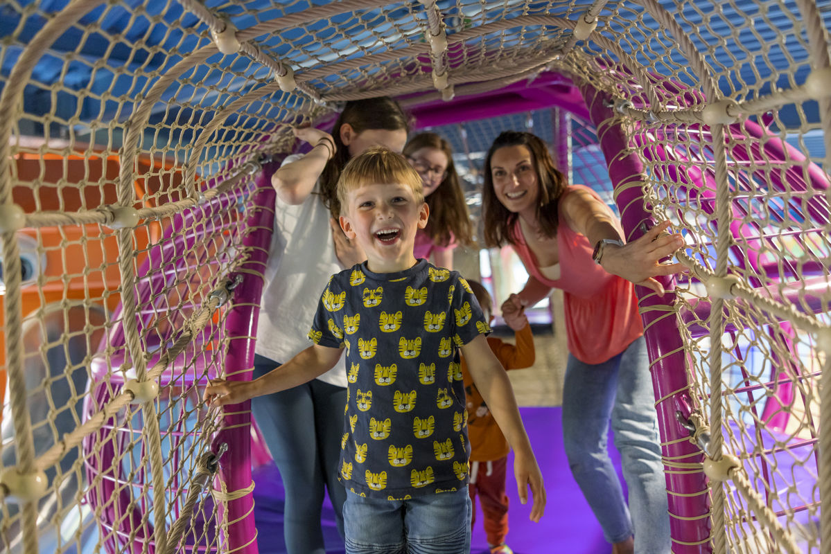 boy and family in netted play area in an indoor play centre