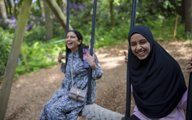 Two women playing on the swing in Tangle Tree Climb