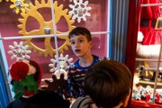 A young boy infront of Santa's Grotto windows
