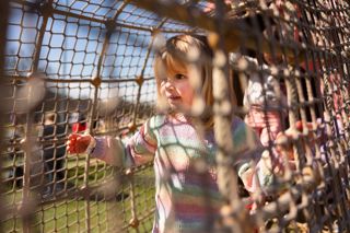 a girl in farmer fosters walking through a netted pathway