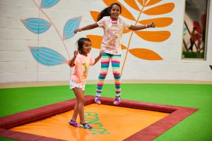 Girls playing on bounce mat in the Playhive central tower