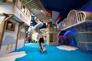 Weather station tower, spiral slide, hot air balloon and high rope bridge in flying zone at Playhive indoor play centre