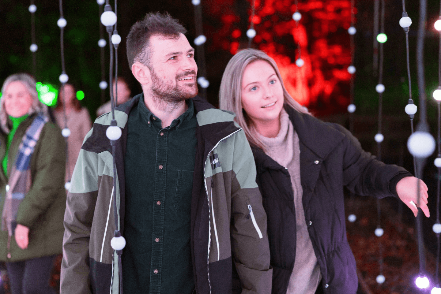 Young couple exploring winter illuminations in Stockeld Parks' Enchanted Forest. 