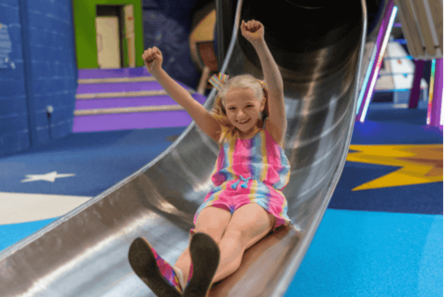 Young girl sliding down a slide in Stockeld Park's indoor Playhive