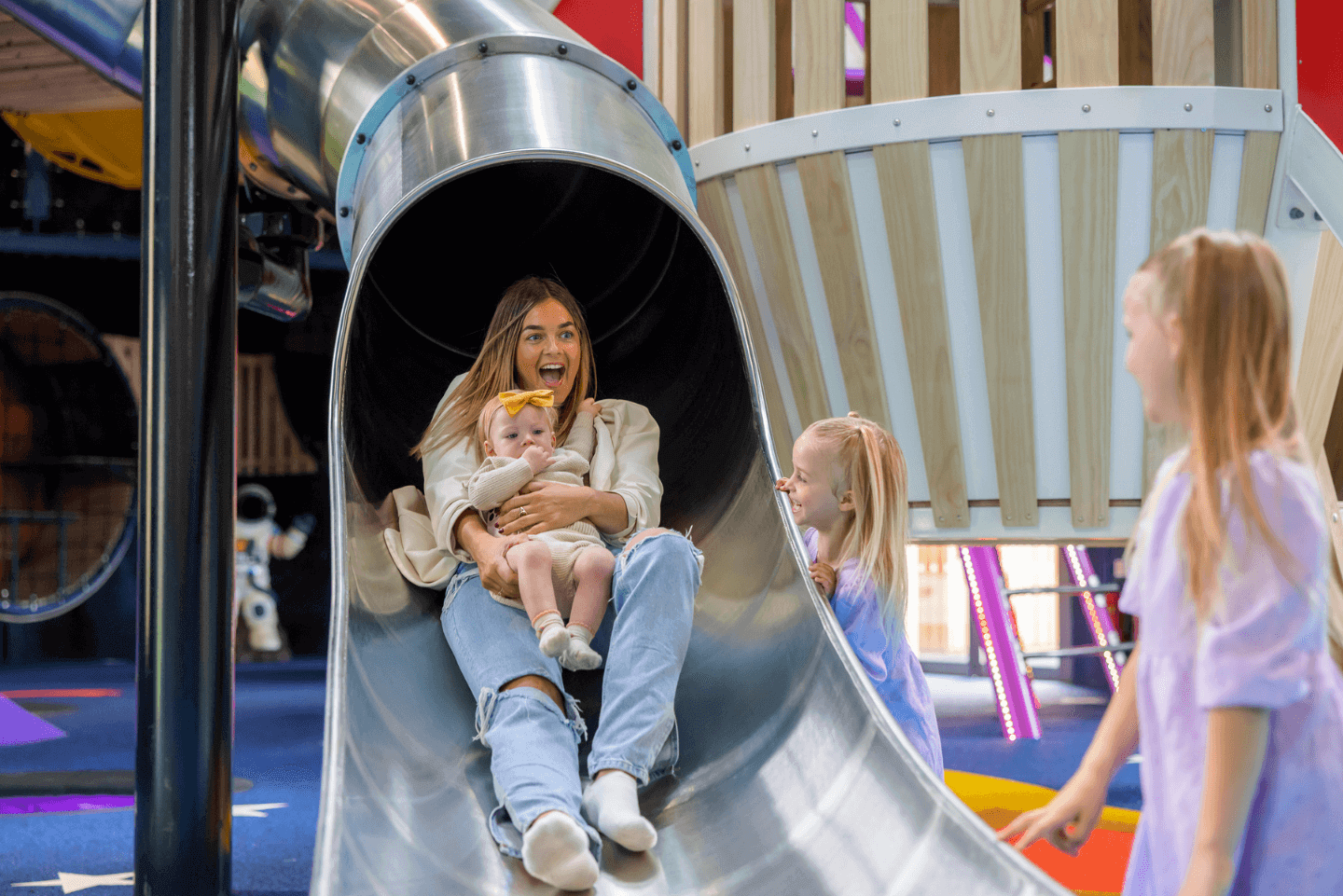 Mother and young child sliding down a helter skelter at Stockeld Park