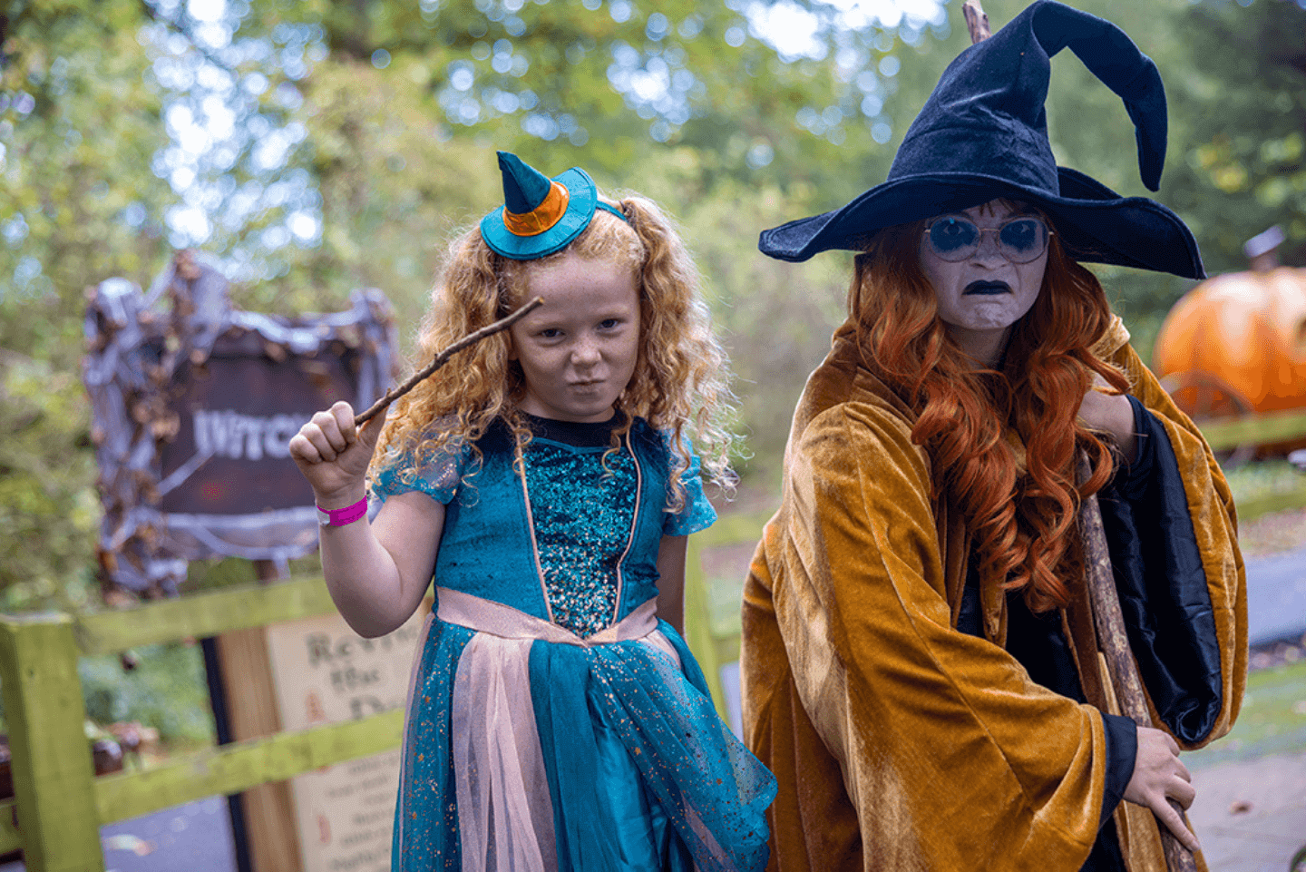 Young girl stood near a woman dressed as a witch